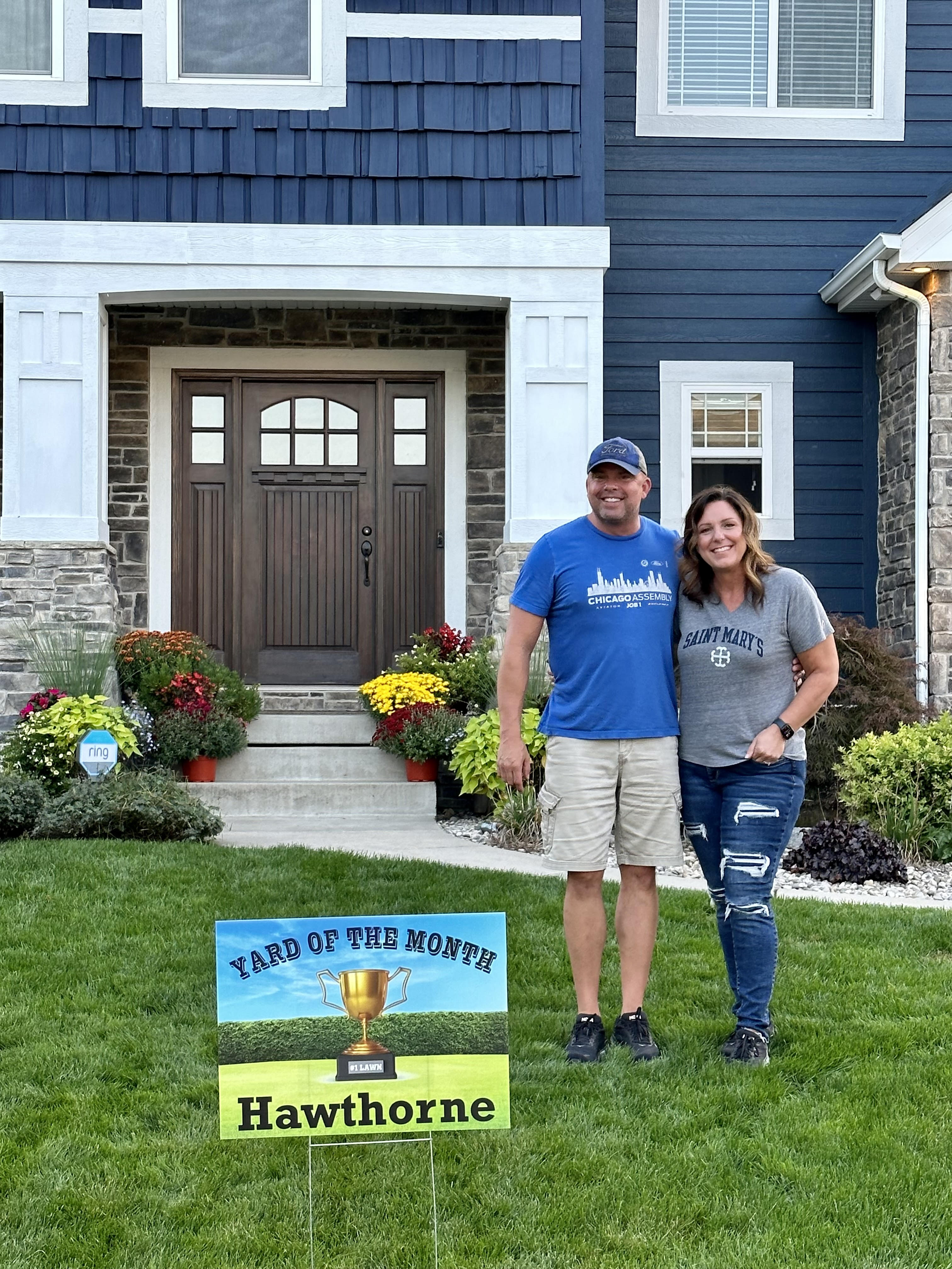 Closeup photo of homeowners and a yard sign in front of a single family home at 2308 Nottingham, Valparaiso, Indiana, 46383.